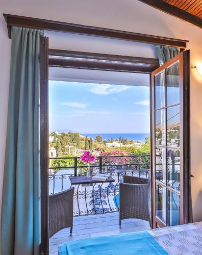 a room with a balcony with a view of the ocean at Mare Garden Hotel in Akyarlar