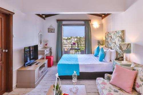 a bedroom with a bed and a tv and a couch at Mare Garden Hotel in Akyarlar