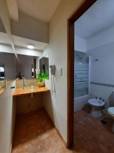 a bathroom with a sink and a toilet and a tub at Complejo Mykonos , Departamentos en Pinamar in Pinamar