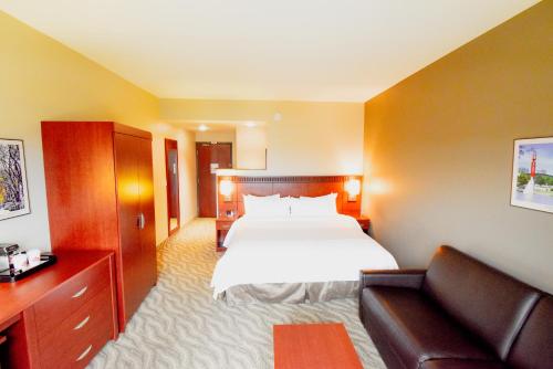 a hotel room with a bed and a couch at Canad Inns Destination Centre Garden City in Winnipeg