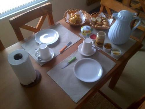 - une table avec des assiettes, un pichet et un bol de nourriture dans l'établissement Desert Tracks Rancho, à Las Grutas