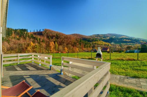a wooden bench in a field with a fence at Siedlisko Leśnica - domki całoroczne Brenna in Brenna