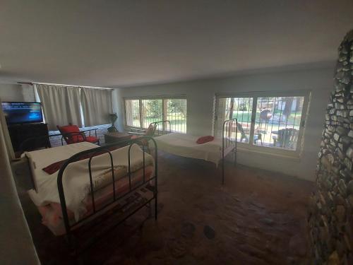 1 dormitorio con 2 camas, TV y ventanas en Casa de Campo entera en 