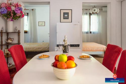 a kitchen table with a bowl of fruit on it at Villa Granić in Promajna