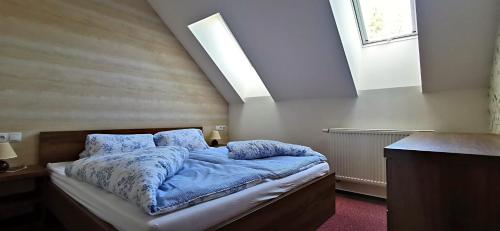 sypialnia z łóżkiem z niebieską pościelą i oknem w obiekcie Apartment No.28 Jasná w Demianowskiej Dolinie