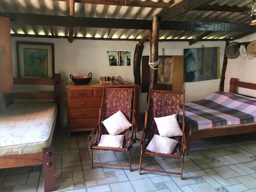 a bedroom with two beds and a dresser and a desk at Rancho do Paollo in Pirenópolis