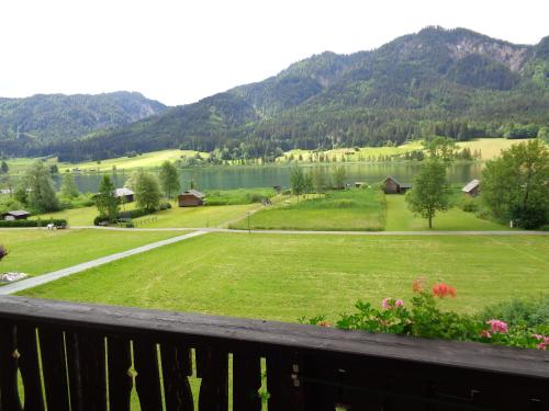 a view from the deck of a house with a green lawn at Haus Alpenfriede in Weissensee