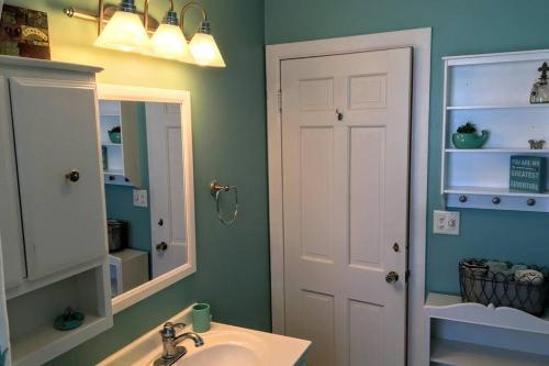 a bathroom with a sink and a mirror at ☆Oakley's Oasis: A Dharma Dwellings Designed Home☆ in Rochester