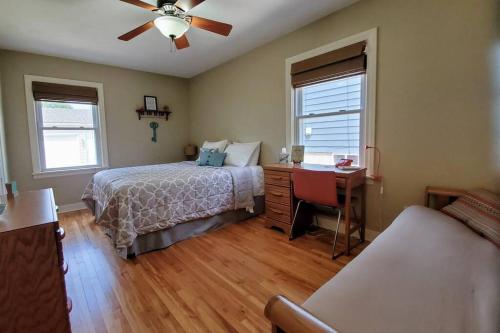 a bedroom with a bed and a desk and a ceiling fan at ☆Oakley's Oasis: A Dharma Dwellings Designed Home☆ in Rochester