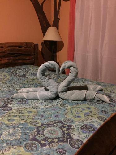 a pair of towelsrendered to look like a heart on a bed at Quinta Mi Tata B&B in Sardinal