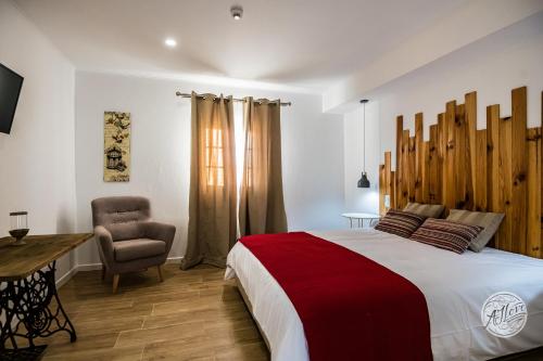 a bedroom with a large bed and a chair at Olívale - Turismo Rural in Campo Maior