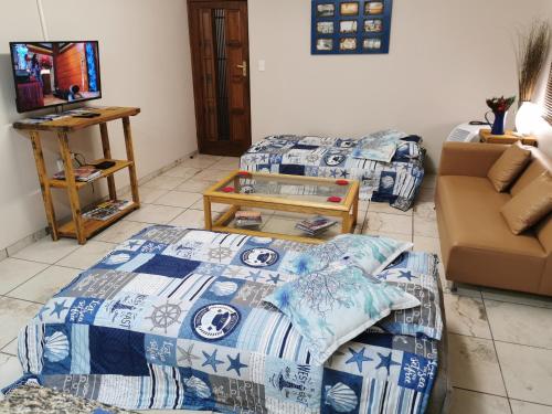 a living room with two beds and a couch at Langebaan Escape Self Catering Accommodation in Langebaan