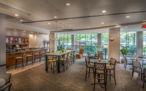 a restaurant with tables and chairs and a bar at Holiday Inn Arlington at Ballston, an IHG Hotel in Arlington