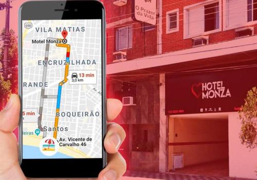 uma mão a segurar um telemóvel com um mapa em Motel Monza (Adult Only) em Santos