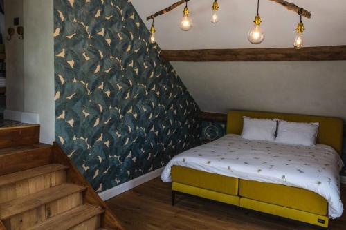 1 dormitorio con cama y pared con pájaros en vakantiewoning maison doute, en Durbuy