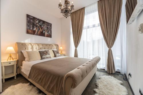 ein Schlafzimmer mit einem großen Bett mit einem großen Fenster in der Unterkunft Aki Studio Silver Mountain Poiana Brasov in Poiana Brașov