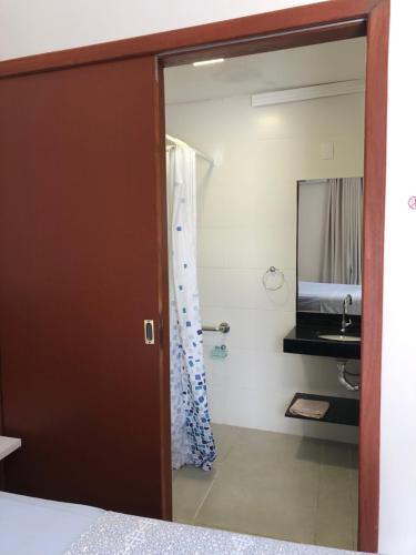 a bathroom with a shower and a sink at Pousada Crisana in Florianópolis