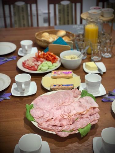 een houten tafel met borden met eten erop bij Hostel Sportowa in Płońsk