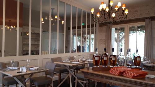 a dining room with tables and bottles of wine at Logis Hôtel Restaurant Relais de la Mothe in Yzeures-sur-Creuse