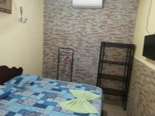 a bedroom with a bed and a brick wall at La Posada De Don Jose in Flores