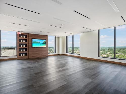 an empty office with a large room with floor to ceiling windows at Bluebird Suites at Reston Town Center in Reston