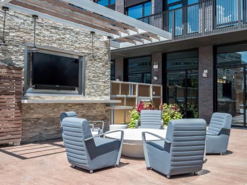 a patio with chairs and a table and a tv at Bluebird Suites at Reston Town Center in Reston