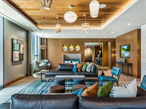 a living room with a leather couch and chairs at Bluebird Suites at Reston Town Center in Reston