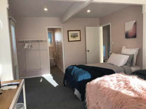 a bedroom with two beds and a room with a table at Allie's Hill Top Haven Bed & Breakfast in Whanganui