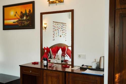 a mirror on a desk with a bottle of wine at Aida Hotel in Cıralı