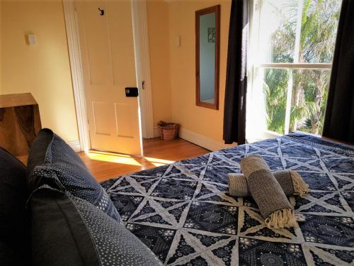 a bedroom with a bed with two towels on it at Endless Summer Lodge - Guesthouse in Ahipara