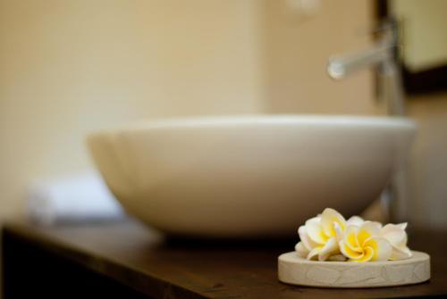 a white bowl and a white flower on a counter at Villa Akasa in Varkala