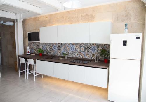 a kitchen with a white refrigerator and a table at U scrusciu du mari - Casuzze SeaSound Holidays in Marina di Ragusa