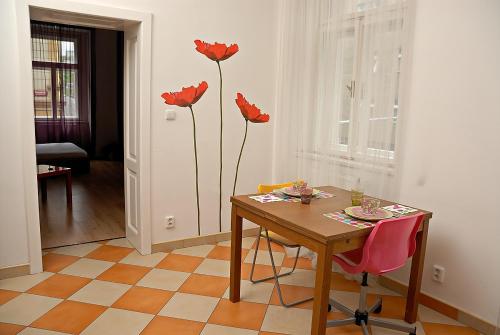 a dining room with a table and red flowers on the wall at Just BE that´s enough!! in Prague