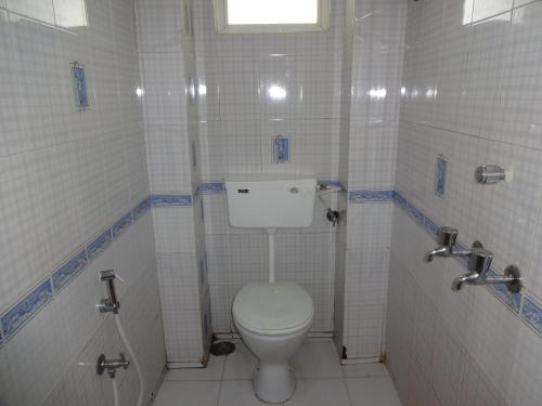 a bathroom with a white toilet in a stall at Marwa Inn in Trivandrum