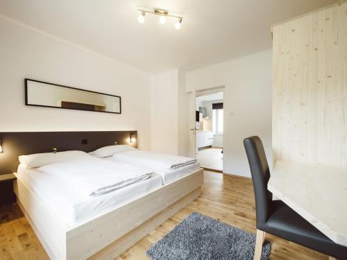 a white bedroom with a large bed and a desk at Heritage Apartment in Eisenerz near Ski Area in Eisenerz