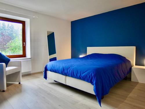 um quarto azul com uma cama e uma janela em Tranquil Holiday Home in Manhay with near Ski Area em Manhay