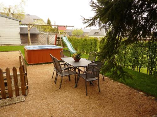 una mesa y sillas en un patio trasero con un tobogán en Traditional Holiday home in B tgenbach with Sauna en Butgenbach