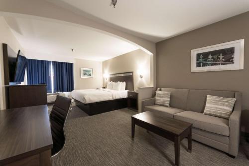 Best Western Abilene Inn and Suites في أبيلين: فندق غرفه بسرير وصاله