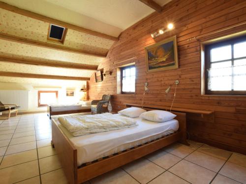 a bedroom with a bed in a room with wooden walls at Wonderful Holiday Home in Noirefontaine in Bouillon
