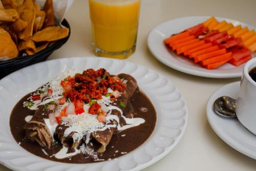a table with two plates of food and a drink at Hotel Palacio in Córdoba