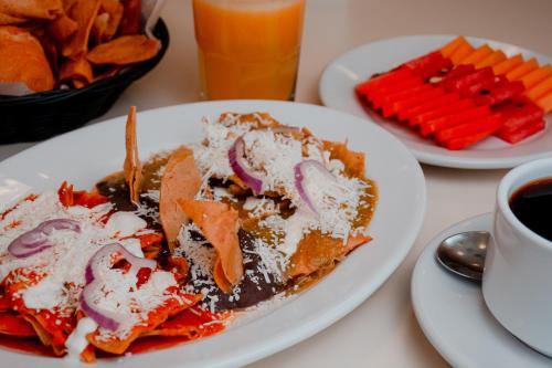 a white plate of food on a table with food at Hotel Palacio in Córdoba