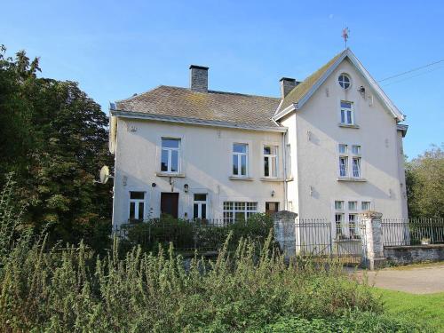 Biały dom z płotem przed nim w obiekcie Splendid Mansion in Bastogne with Fenced Garden w mieście Le Parque