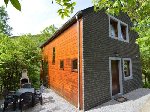 a black and orange house with a table and chairs at Comfortable modern chalet with wood finish in Aywaille