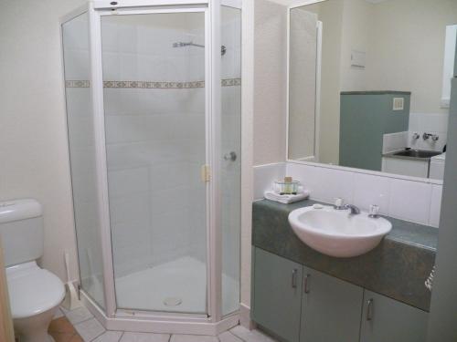 un baño con ducha y lavabo en Palm Cove Tropic Apartments, en Palm Cove