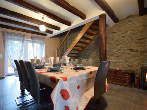 a dining room with a table with chairs and a table cloth at Pretty cottage with billart and 2 bathrooms in Marfontaine
