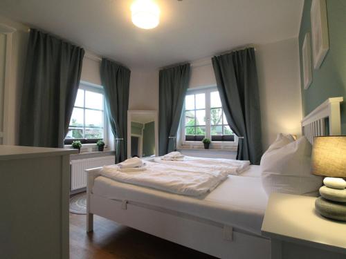 - une chambre avec un grand lit blanc et 2 fenêtres dans l'établissement Charming Holiday Home in Robertsdorf on Baltic Coast, à Robertsdorf