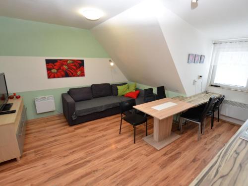 a living room with a couch and a table at Comfy Holiday Home near Forest in Medenec in Měděnec