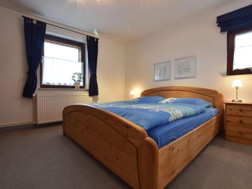 クリュツにあるStylish Apartment with Garden in Kl tz Germanyのベッドルーム1室(大型木製ベッド1台、青いシーツ付)