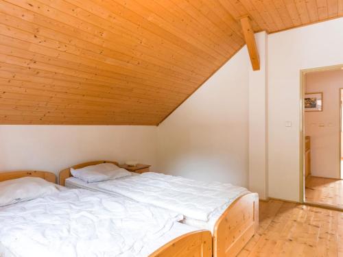 two beds in a room with a wooden ceiling at Holiday Home in Javorník near Giant Mountains in Rudník