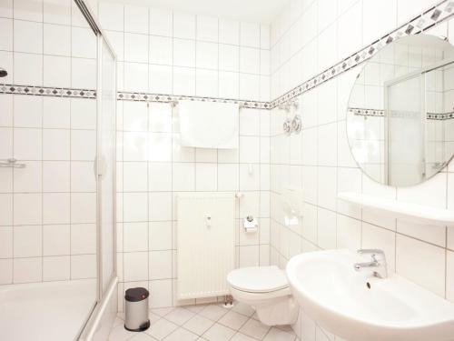 a white bathroom with a toilet and a sink at Peaceful Villa in Borstendorf in Leubsdorf